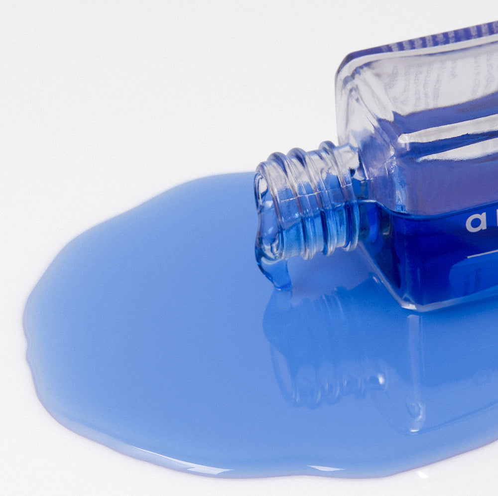 anokha skincare blue lotus body oil bottle on side spilling blue oil